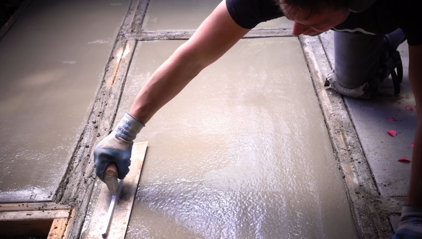 Skilled concrete finisher troweling fresh concrete surface for a smooth, durable result in Hayward, CA