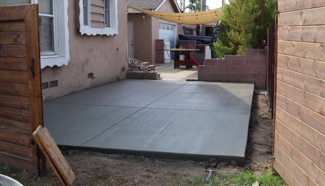 Freshly poured concrete patio installation in a Hayward backyard